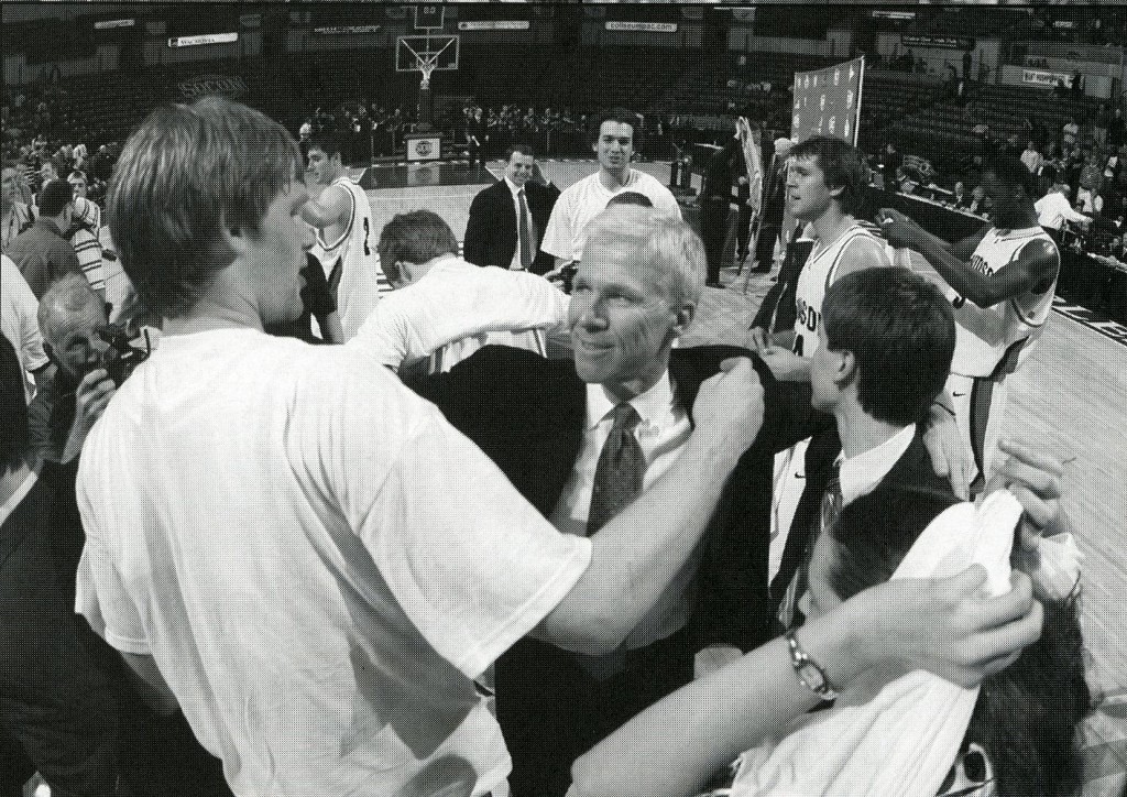 McKillop on the court with players, from the 2009 - 2010 media guide.