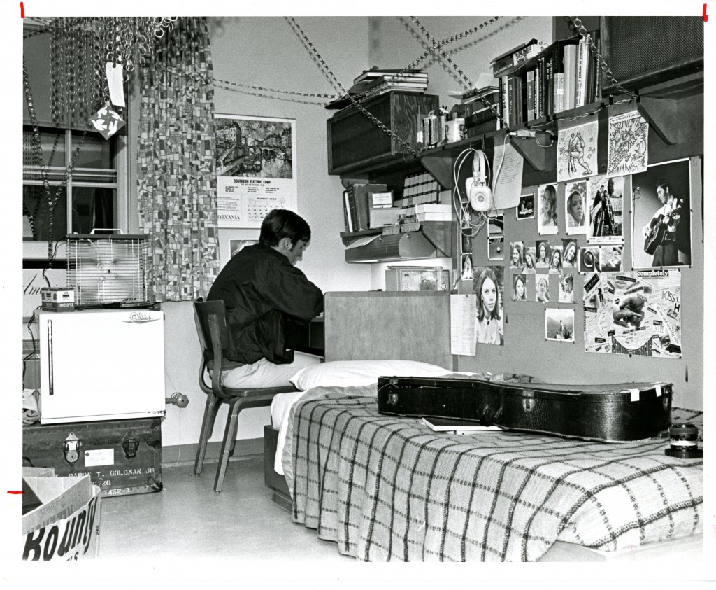 John Cronin's (Class of 1971) dorm room in 1969 provides a glimpse into his hobbies and loved ones - the guitar case, headphones, and photo of a musician speak to his interest in music. Whether the chains serve a functional or aesthetic purpose is unclear, however (photograph taken by George Sproul, Class of 1970).