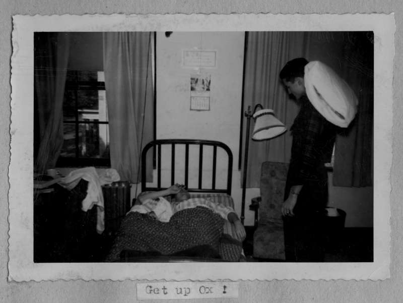 "Get up Ox!" - a sleepy student is awakened in Georgia dorm, under his decorations. This photograph is from a 1948 Phi Gamma Delta scrapbook.